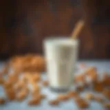 A glass of almond milk with almonds scattered around